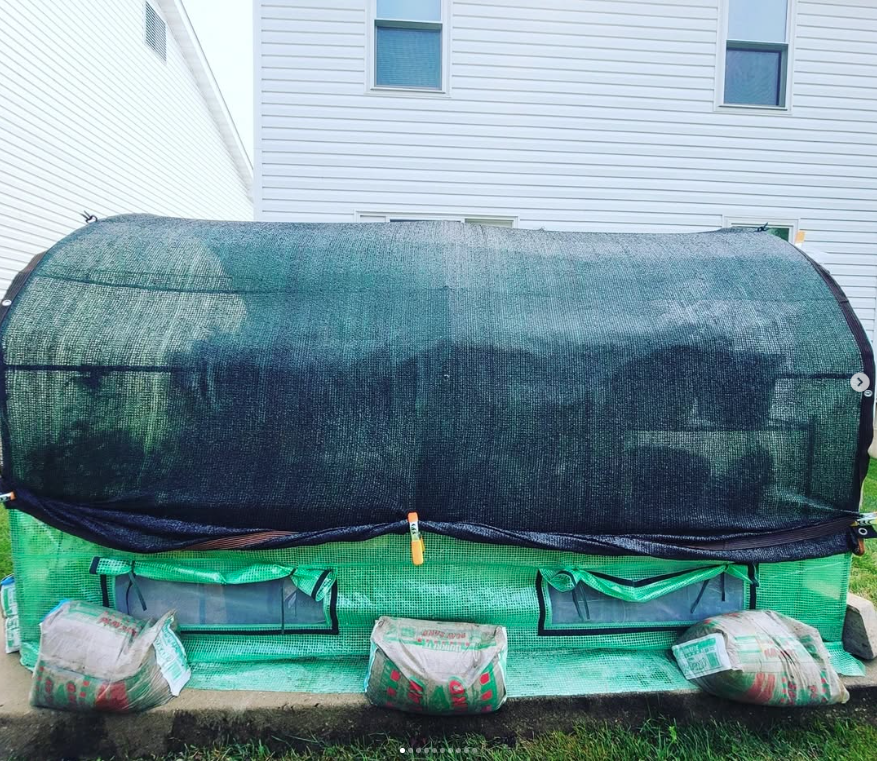 Shade cloth secured over walk-in tunnel greenhouse